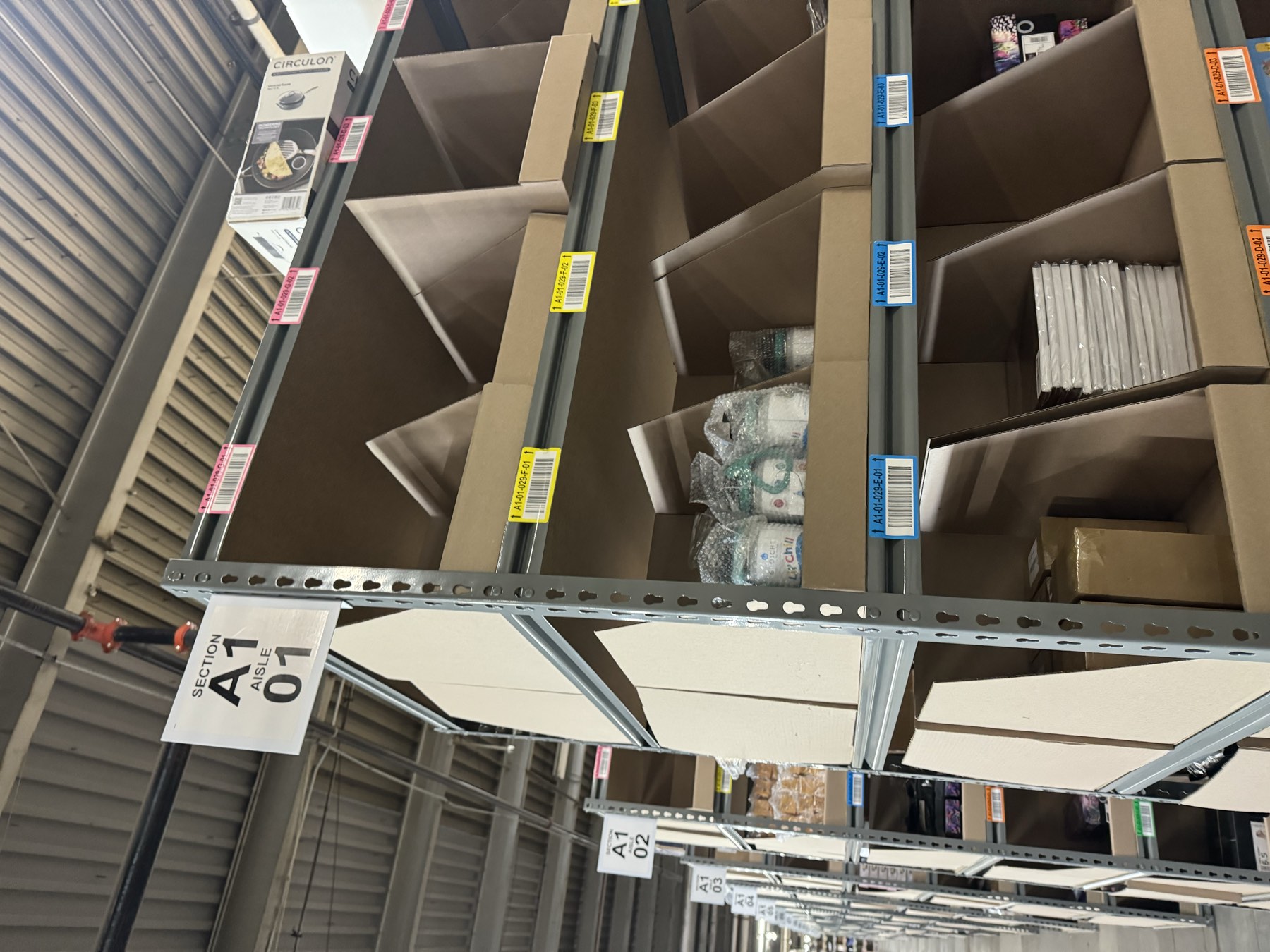 Forward-pick shelving with labeled locations and divided inventory bins