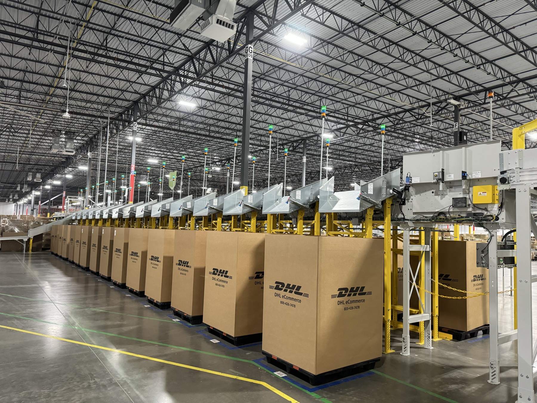Warehouse sortation equipment with shipping containers along the conveyor